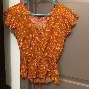 Burnt orange polka dot blouse.